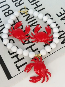 Dettaglio della collana con pendente a granchio rosso e orecchini coordinati mare