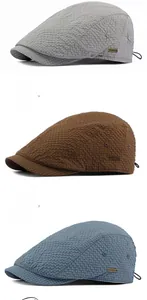 Detail view of waffle texture flat caps in grey, brown, and haze blue with side metal logo