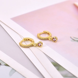 Detailed close-up of gold earrings with sparkling pink and white cubic zirconia stones