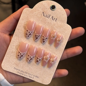 Détail de faux ongles amande avec motif léopard et accents floraux en relief 3D