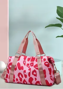 Detail of pink leopard print fitness bag with gold hardware on a modern studio background