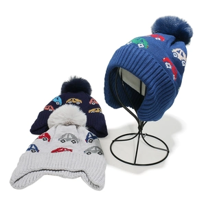 Winter kids knit beanie with earflaps, pom-poms and colorful car patterns in gray and blue
