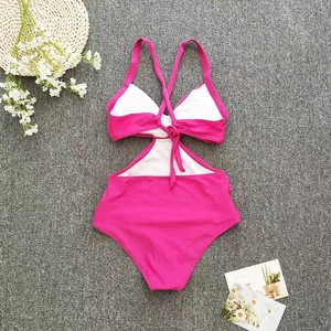 Detail of fuchsia cut-out swimsuit with halter neck and lace-up back on beach-style background