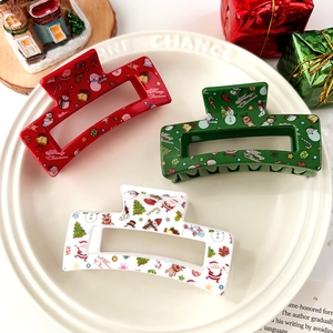 Close-up of colorful Christmas hair claws with festive reindeer and snowman patterns