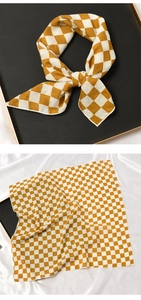 Détail d'un foulard en coton et lin à carreaux jaunes et blancs sur fond de soie douce