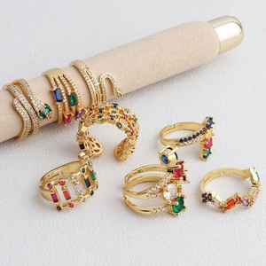Detail of gold-plated rings set featuring colorful zircons on a beige suede display