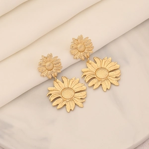 Elegante goldene Sonnenblumen-Ohrhänger mit doppellagigem Blütenblatt-Design auf Marmor