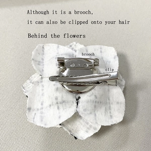 Detail showing the functional dual-use brooch pin and hair clip on the fabric flower back