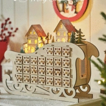 Detail of wooden Christmas advent calendar sled with 24 drawers and LED glowing house