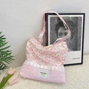Detail of cute pink floral tote bag with heart quilting and lace trim on white fur rug