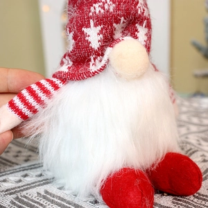 Detailed close-up of a red and white knitted Christmas gnome with soft plush beard