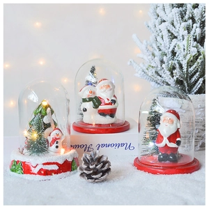 Close-up of LED Christmas glass dome with Santa and snowman on a snowy base
