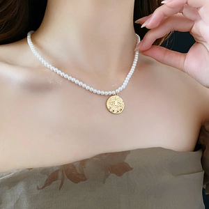 Vue détaillée du pendentif œil plaqué or avec zircons colorés sur collier de perles