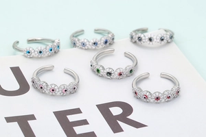 Macro detail of six evil eye rings with colorful enamel and zircon settings