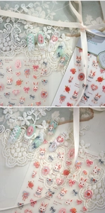 Detail of embossed 3D nail stickers featuring cute rabbits, cherries and bows on mint nails