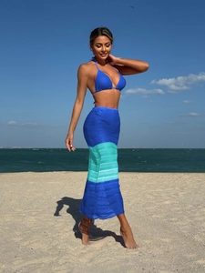 Dettaglio della gonna da spiaggia in maglia sfumata blu e set bikini con allacciatura