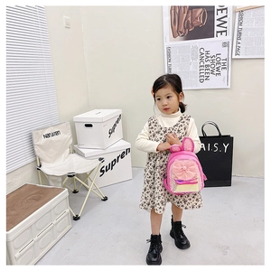 Detail of pink sequin kids backpack with large mesh bow and long bunny ears on a model