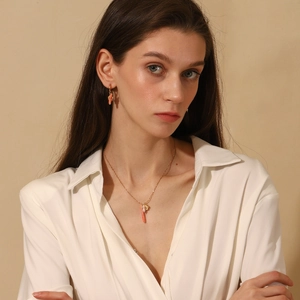 Detail of 18K gold plated necklace and earrings set with pink and pearl beads
