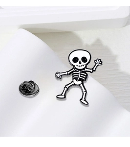 Detail of skull enamel pin with butterfly clasp on white geometric prop background