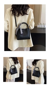 Close-up of black lychee grain bucket bag with a stylish black and white checkered silk scarf