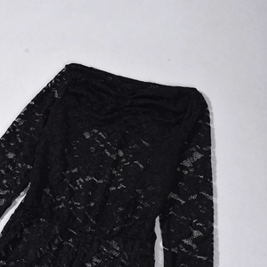 Detailed view of the delicate black floral lace texture and intricate openwork pattern