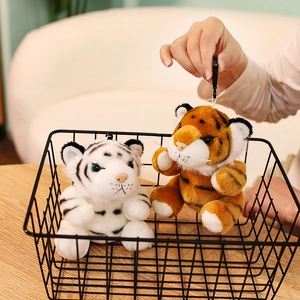 Süße Plüsch-Tigeranhänger in Weiß und Gelb, dekoriert in einem kleinen schwarzen Korb
