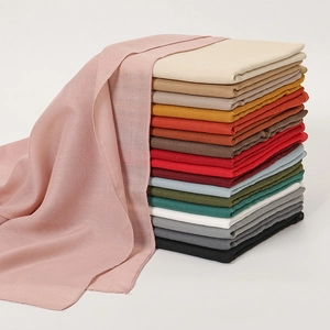 Solid color minimalist linen cotton scarf for women shown in various stacked colors