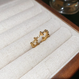 Macro detail of 18k gold plated cross flower ring with white zircons in a jewelry box