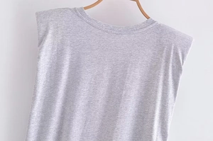 Dettaglio maglietta grigia senza maniche con spalline e texture in cotone a maglia