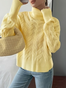 Close-up of yellow knit sweater featuring diamond texture pattern and cozy high turtleneck