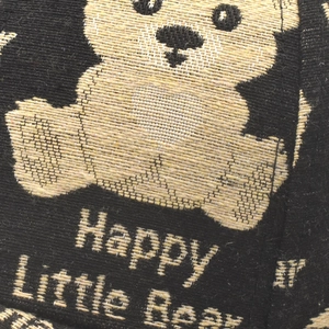 Macro detail of knitted fabric showing the Happy Little Bear embroidery pattern