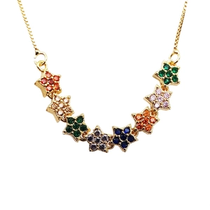 Close-up of golden necklace with seven small stars inlaid with colorful zircon stones