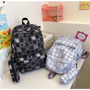 Detail of grid pattern school backpacks in black and purple with matching pencil cases