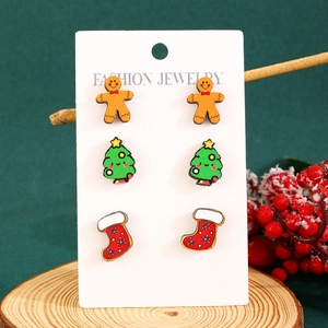 Detailed close-up of Christmas stud earrings set with gingerbread man and festive tree
