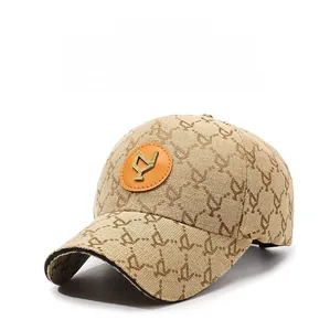 Detail of khaki baseball cap featuring letter embroidery and circular leather logo patch