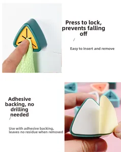 Macro detail of punch-free wall towel clip showing press mechanism and adhesive backing