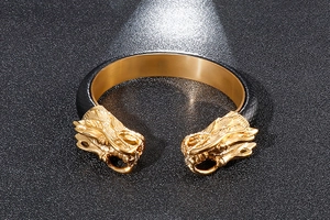 Detailed view of the double dragon head bracelet in gold finish and black leather