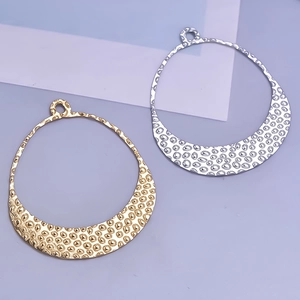 Detail of crescent pendants with hammered texture in gold and silver finish