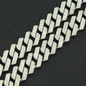 Macro detail of silver S-link chain with sparkling pavé crystals on a black background