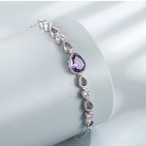 Detail of silver bracelet featuring a teardrop purple stone and white zircon accents