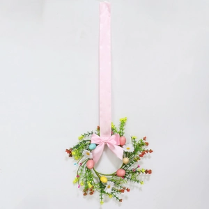 Close-up of Easter wreath with white daisies, colorful eggs, and a long pink silk bow