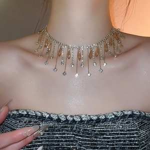 Detail of luxury crystal fringe necklace with champagne rhinestones on a model's neck