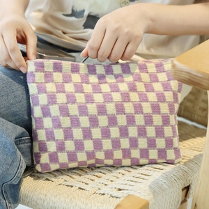 Knitted checkerboard makeup bag in purple and yellow with zipper closure