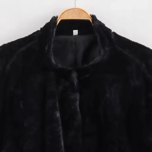 Black faux fur aviator jacket for women displayed on a wooden hanger against a grey wall
