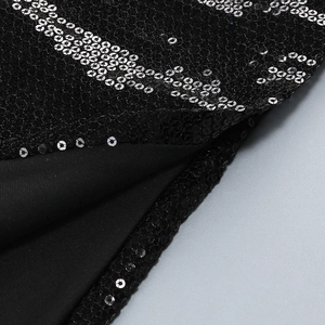 Detail view of shimmering black sequins and 3D floral embroidery on a fish tail dress
