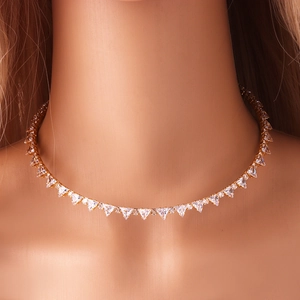 Close-up of elegant gold choker necklace with sparkling triangular zircon stones on neck