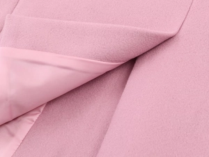 Detailed close-up of pink oversized blazer showing wool-like fabric and satin lining texture