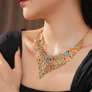 Close-up of vintage gold leaf necklace with colorful crystals on professional model