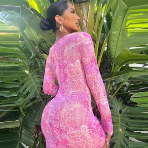 Pink snakeskin print long sleeve bodycon dress modeled in a lush tropical garden