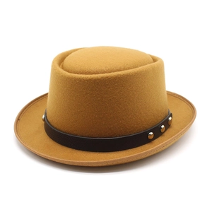 Détail d'un chapeau en feutre gingembre avec bande en cuir brun et rivets en métal